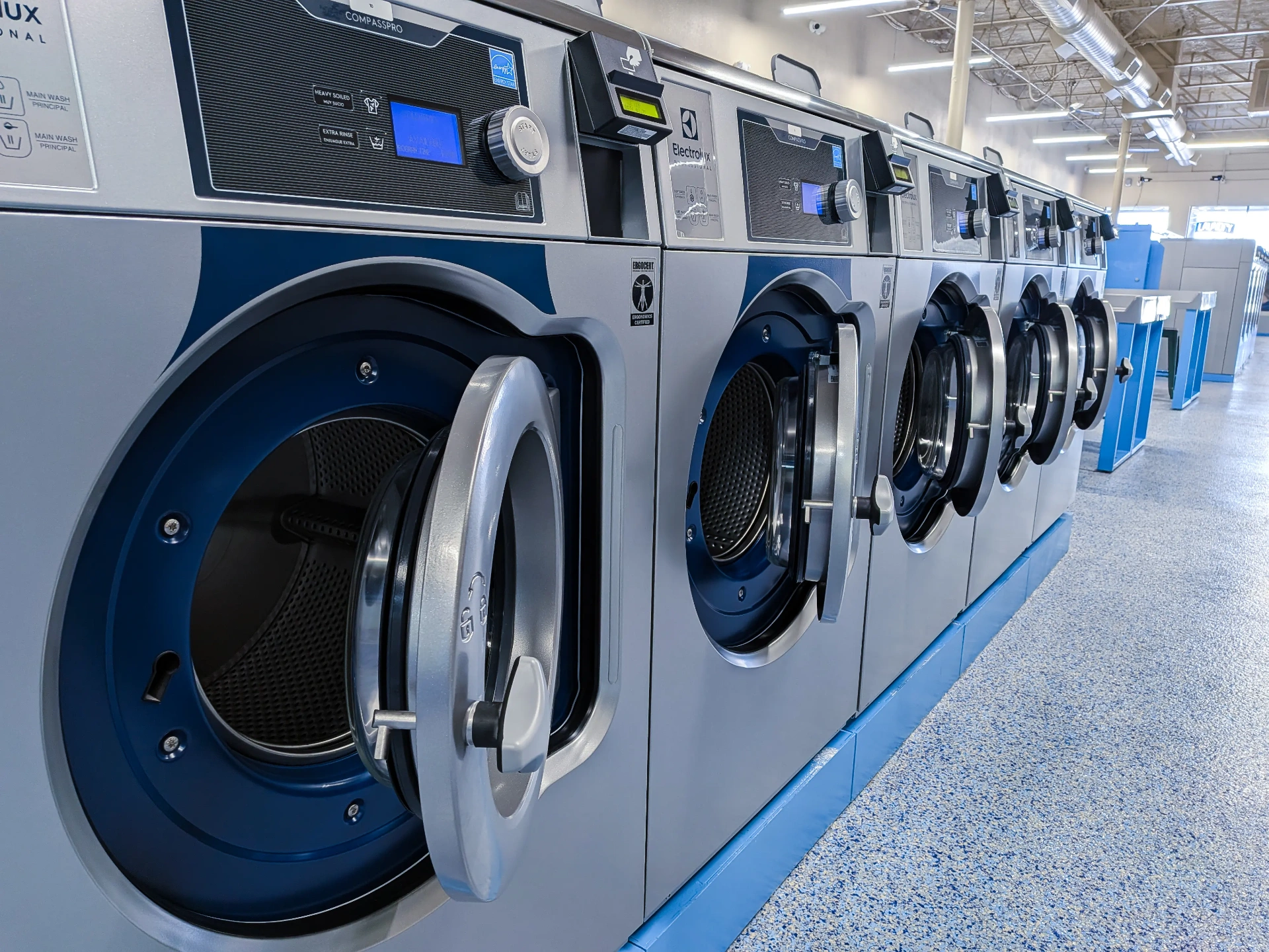 Row of brand-new Electrolux CompassPro commercial washers at the Fort Worth laundry facility